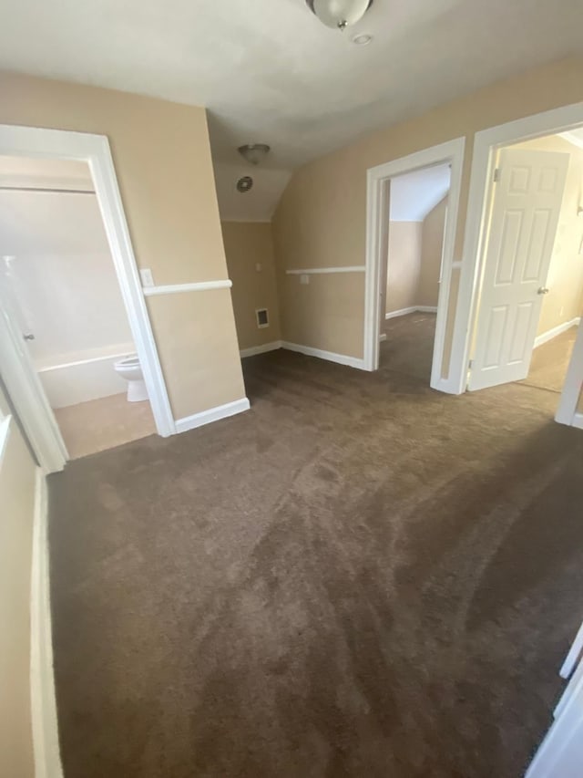 additional living space featuring visible vents, lofted ceiling, carpet, and baseboards