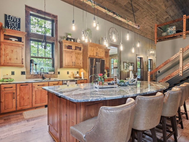 kitchen featuring appliances with stainless steel finishes, high vaulted ceiling, brick ceiling, sink, and a large island