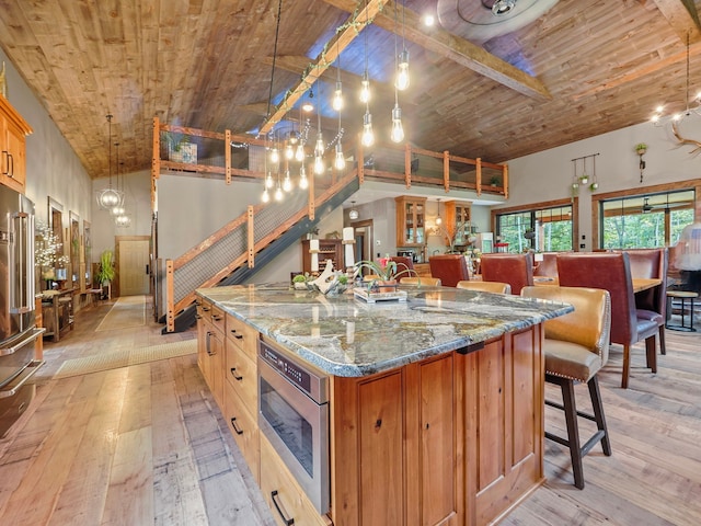 kitchen featuring a spacious island, wood ceiling, beam ceiling, and hanging light fixtures