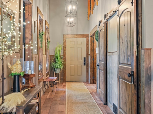 interior space featuring a barn door, a chandelier, and a high ceiling