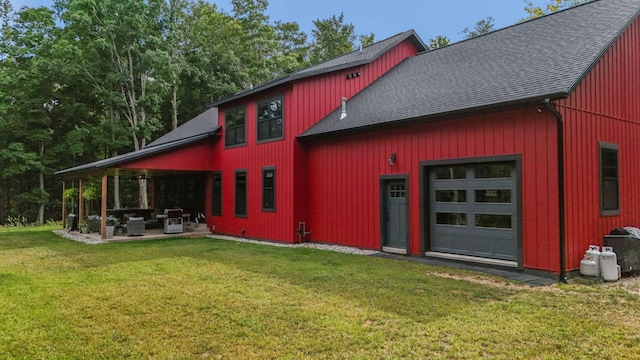 exterior space featuring a garage, a patio, and a lawn