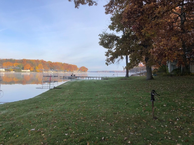 view of dock featuring a lawn and a water view