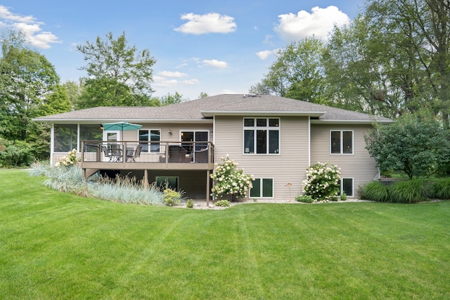 rear view of property featuring a sunroom, a yard, and a wooden deck