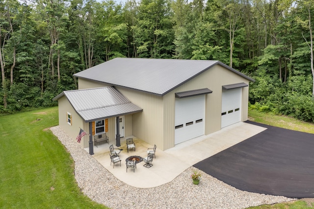 view of front of property featuring a patio, a fire pit, and a front lawn