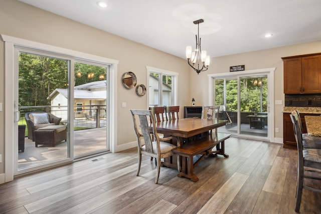 dining area featuring light wood-type flooring and an inviting chandelier