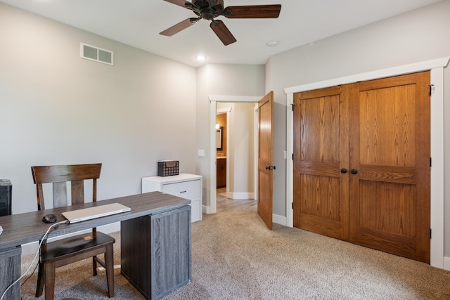 carpeted office space featuring ceiling fan