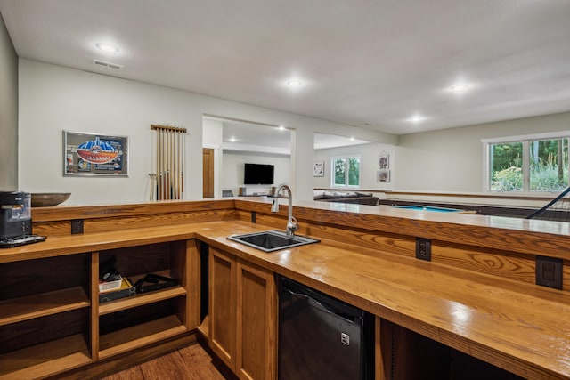 kitchen featuring wood counters, sink, plenty of natural light, and black dishwasher