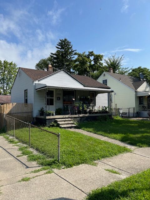 bungalow with covered porch and a front yard