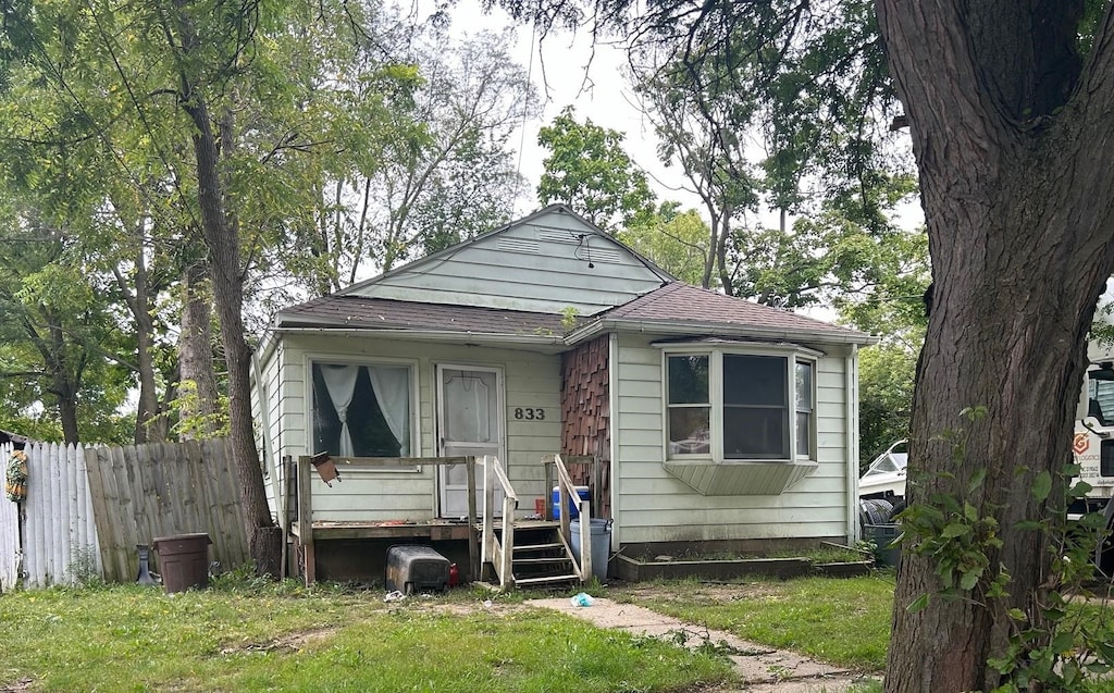 bungalow-style home featuring a front yard