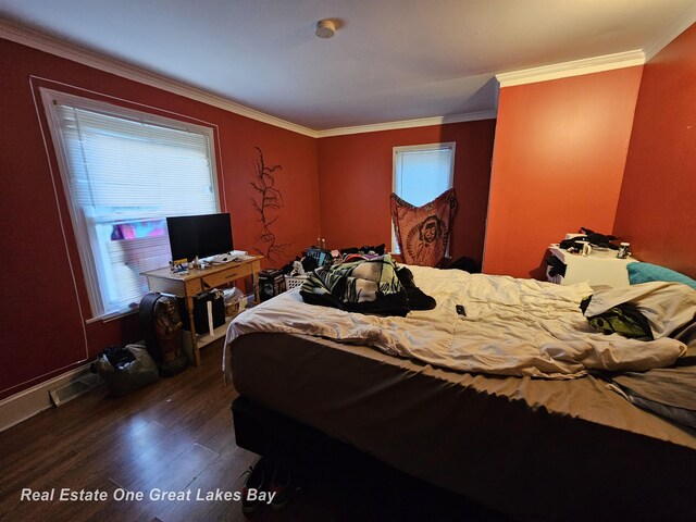 422 N Woodbridge St, Saginaw, MI 48602 - bedroom with dark wood-style floors and crown molding