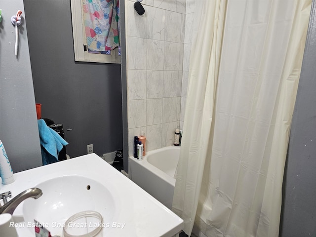 bathroom featuring shower / bath combo with shower curtain and sink