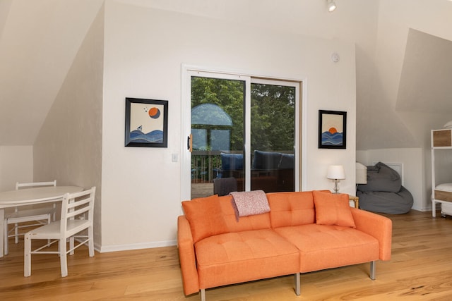 living room with light wood-type flooring and vaulted ceiling