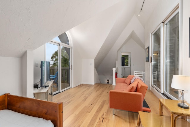 bonus room with a textured ceiling, light hardwood / wood-style flooring, and vaulted ceiling