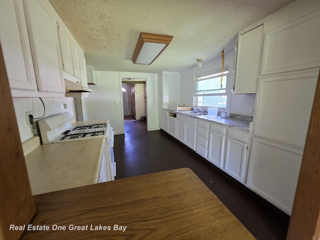 3810 Nicol Dr, Saginaw, MI 48601 - kitchen featuring white gas range, under cabinet range hood, white cabinets, light countertops, and a textured ceiling