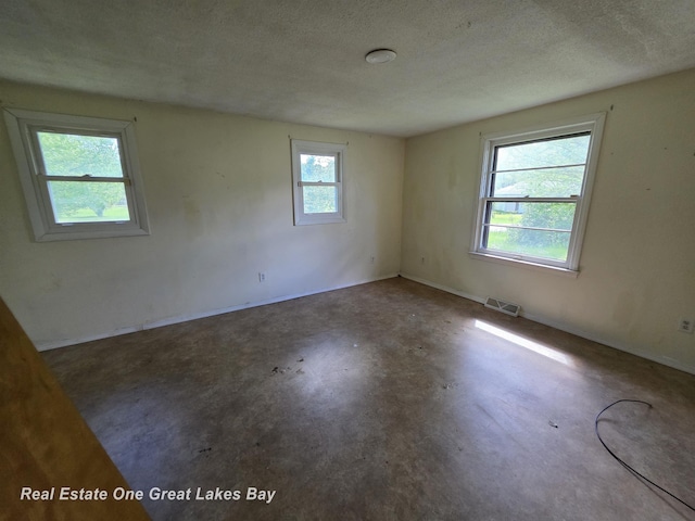 3810 Nicol Dr, Saginaw, MI 48601 - unfurnished room with unfinished concrete floors, a textured ceiling, and baseboards