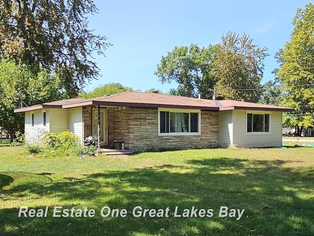 3810 Nicol Dr, Saginaw, MI 48601 - view of front facade featuring stone siding and a front lawn
