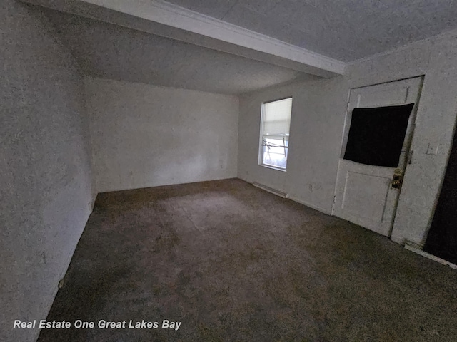 carpeted empty room featuring beamed ceiling