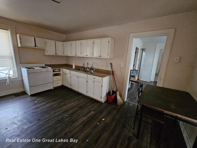 kitchen with white cabinets, dark wood-type flooring, sink, and white range with gas cooktop