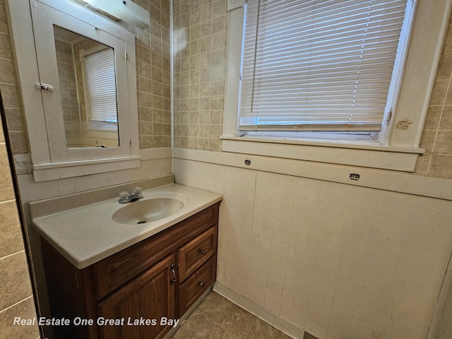 bathroom featuring tile patterned floors, vanity, and wooden walls