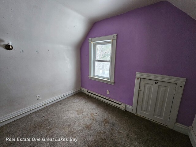 additional living space with vaulted ceiling, carpet floors, and a baseboard radiator