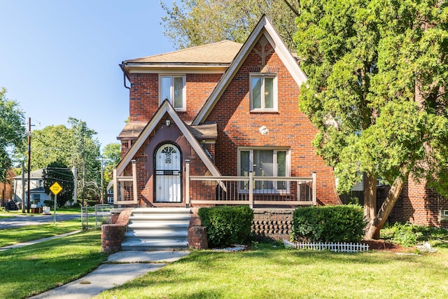 tudor-style house featuring a front yard