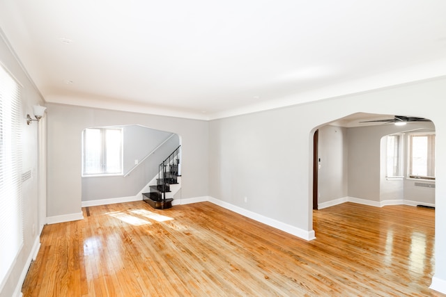 empty room with hardwood / wood-style floors, ceiling fan, and a wealth of natural light