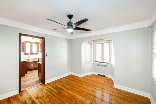 unfurnished room featuring ceiling fan, sink, and light hardwood / wood-style flooring