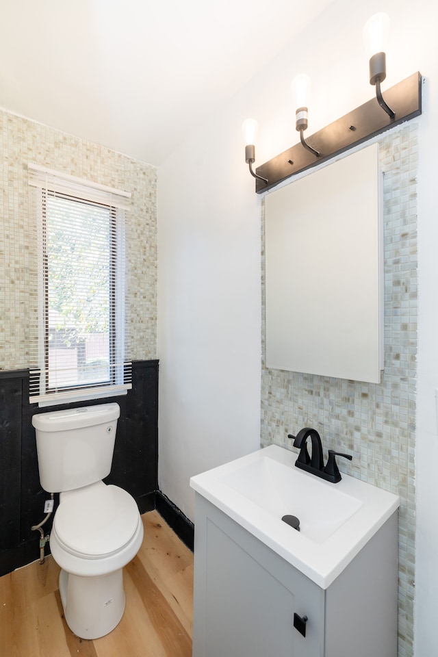 bathroom featuring hardwood / wood-style floors, vanity, tile walls, and toilet