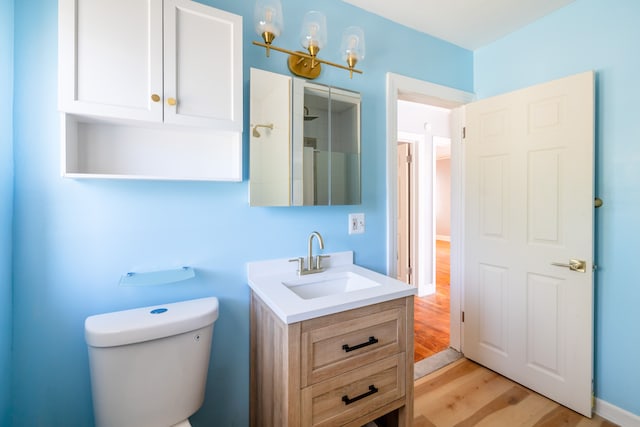 bathroom with hardwood / wood-style floors, vanity, a shower, toilet, and a chandelier