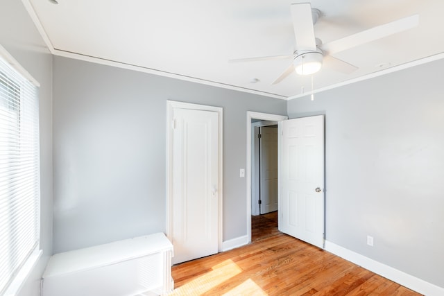 unfurnished bedroom featuring ceiling fan, light hardwood / wood-style flooring, and ornamental molding