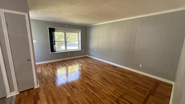 spare room featuring crown molding and dark hardwood / wood-style floors