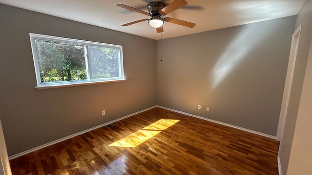 empty room with dark hardwood / wood-style flooring and ceiling fan