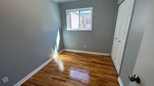 unfurnished room featuring hardwood / wood-style floors and ornamental molding