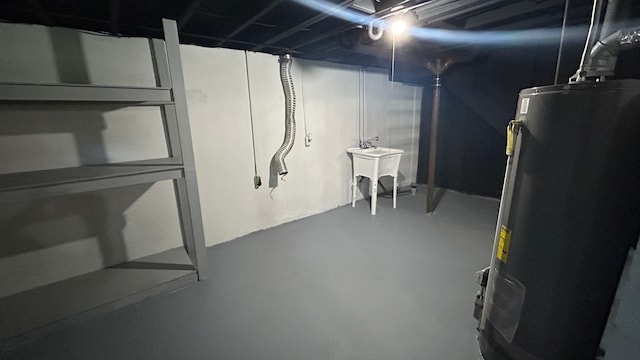 basement featuring gas water heater and sink