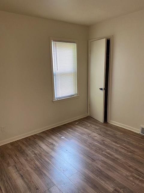 empty room with dark wood-type flooring