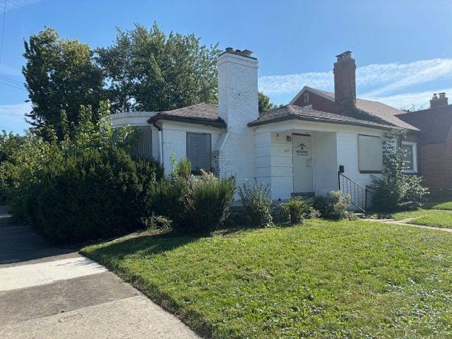 single story home with a front lawn