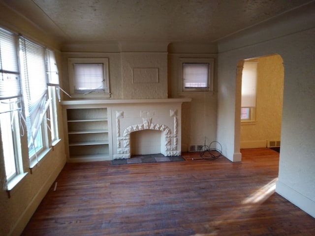 unfurnished living room featuring hardwood / wood-style floors and a textured ceiling