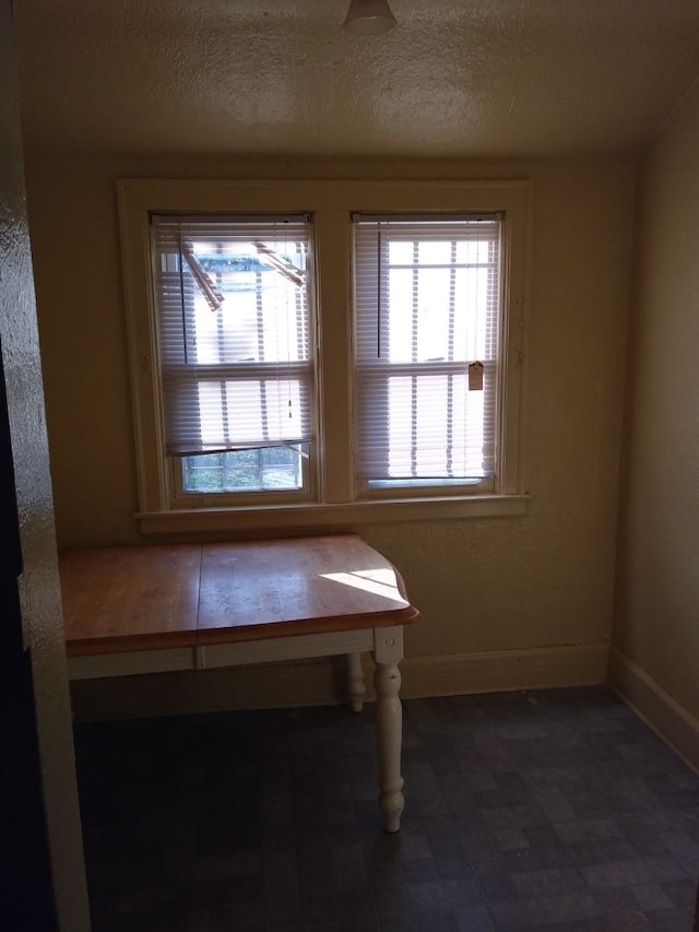 unfurnished dining area featuring a textured ceiling