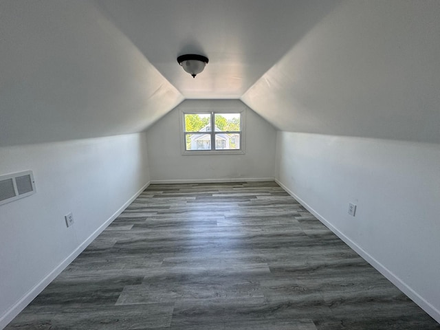 additional living space featuring dark hardwood / wood-style floors and vaulted ceiling