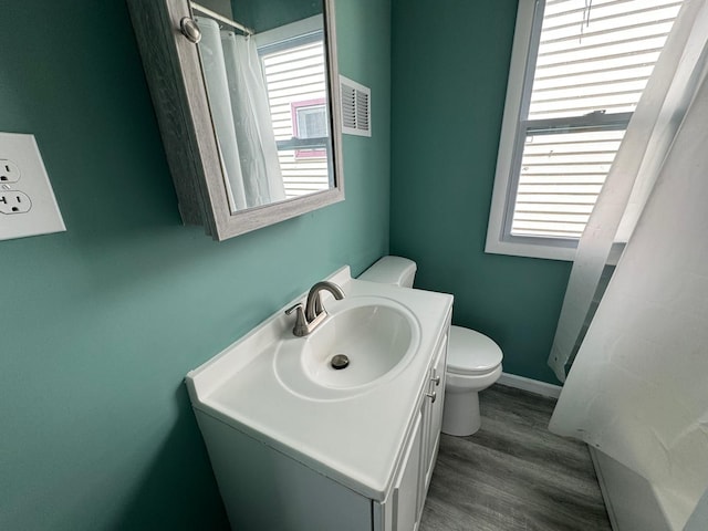 bathroom featuring toilet, vanity, and hardwood / wood-style flooring