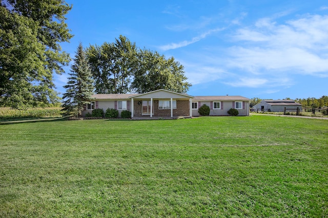 ranch-style house featuring fence and a front lawn
