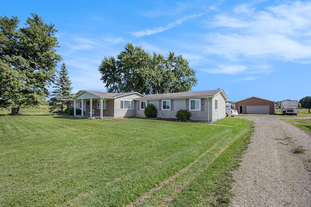 single story home featuring a garage, an outbuilding, and a front yard