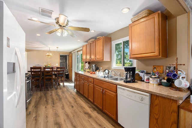 kitchen featuring ceiling fan, sink, hanging light fixtures, white appliances, and light wood-type flooring