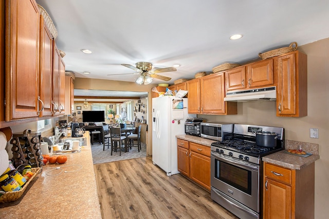 kitchen with ceiling fan, sink, stainless steel appliances, and light hardwood / wood-style floors