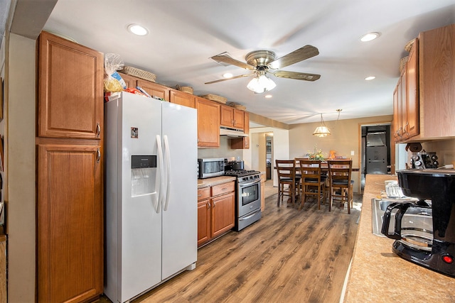 kitchen featuring hardwood / wood-style flooring, decorative light fixtures, ceiling fan, and appliances with stainless steel finishes