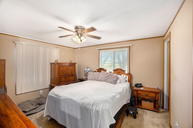 carpeted bedroom featuring ceiling fan, ornamental molding, and a textured ceiling