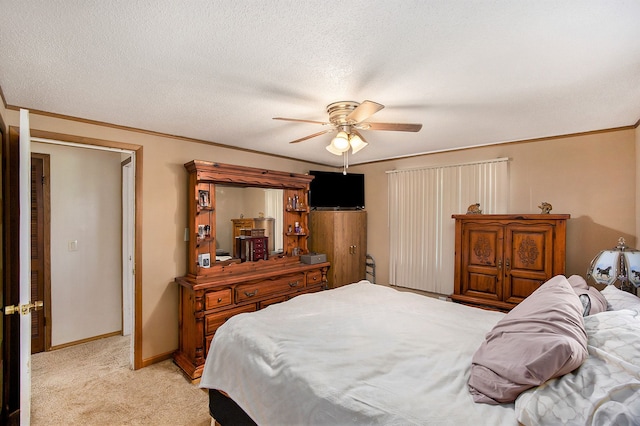 carpeted bedroom with ceiling fan, a textured ceiling, and ornamental molding