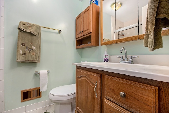 bathroom with tile patterned flooring, vanity, a shower with shower door, and toilet