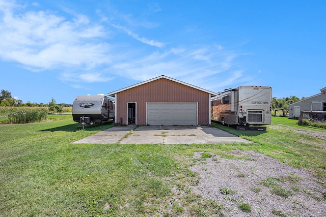 view of front facade with a front yard, an outbuilding, driveway, and a garage