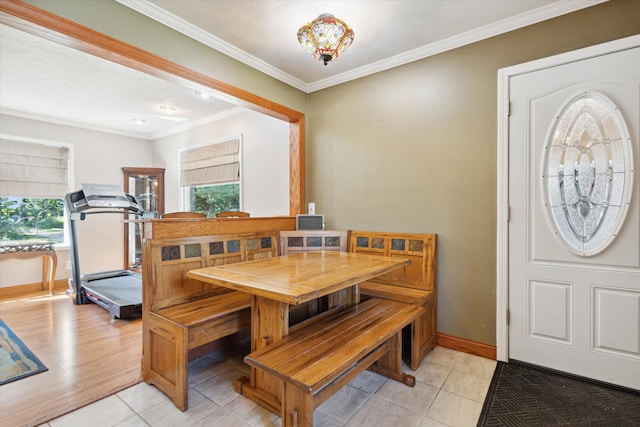 dining room featuring light tile patterned floors and crown molding